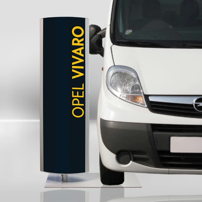 Eine Logosäule in Schwarz mit gelben Aufdruck "OPEL VIVARO". Die Bodenplatte ist verbreitert um darauf den Vorderreifen eines Fahrzeugs im Verkaufsraum abzustellen.